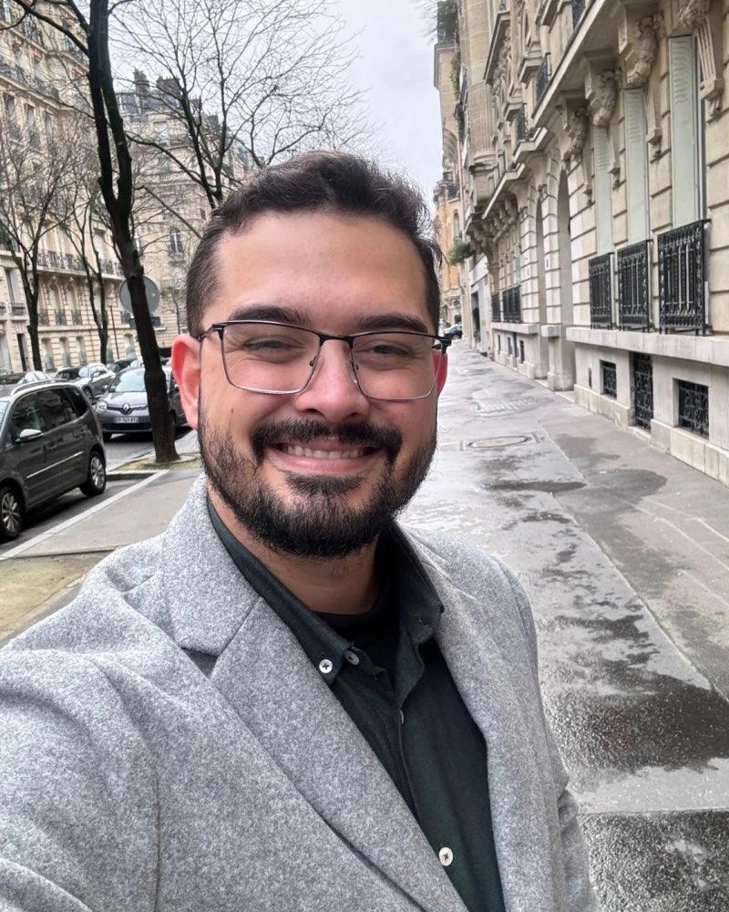 Vitor Figueredo smiling on a street in Paris